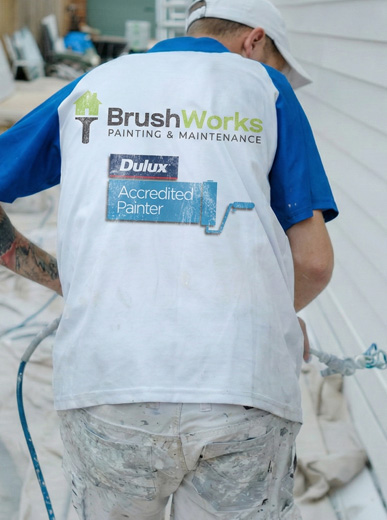 Brushworks house painter and plasterer working in a branded painting shirt