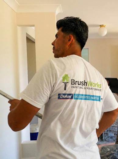 Brushworks painter and project manager wearing a branded shirt on an interior painting project