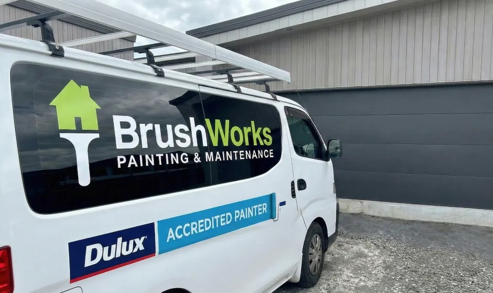 Side of a white Brushworks Painting & Maintenance van showing the Brushworks logo and Dulux Accredited Painter signage